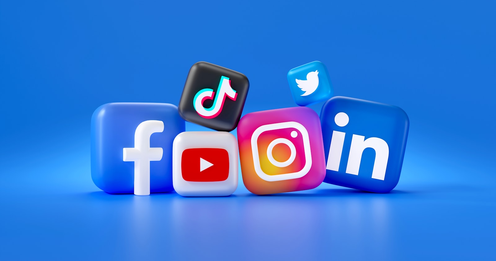 Biểu tượng 3D của Facebook, TikTok, YouTube, Instagram và LinkedIn xếp cạnh nhau trên nền xanh dương